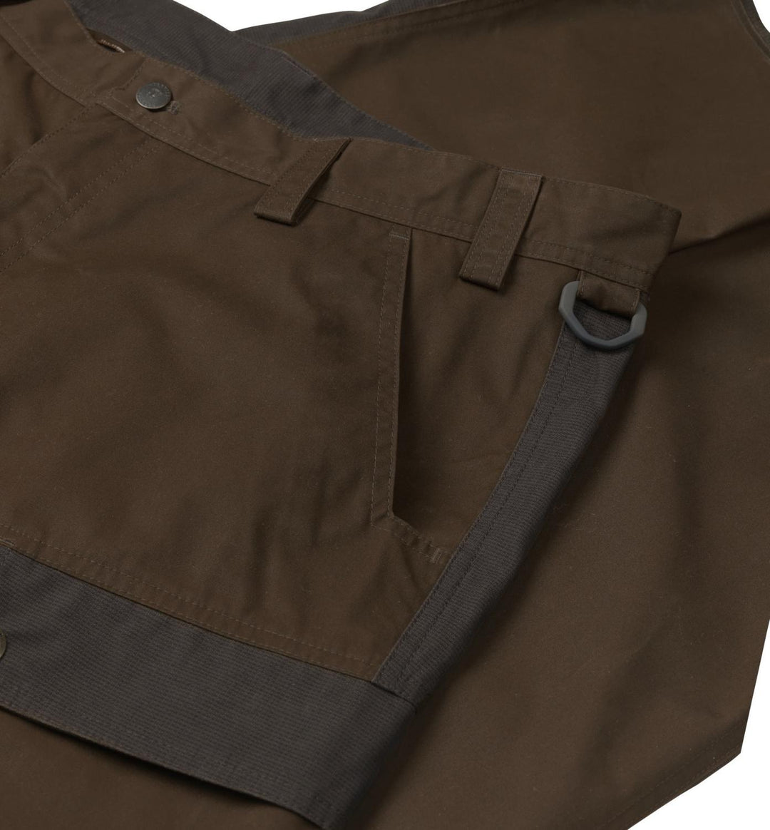 Close-up of the Harkila Asmund trousers side waist, showing a metal D-ring hung from a belt loop, the side pocket opening and charcoal contrast trim.