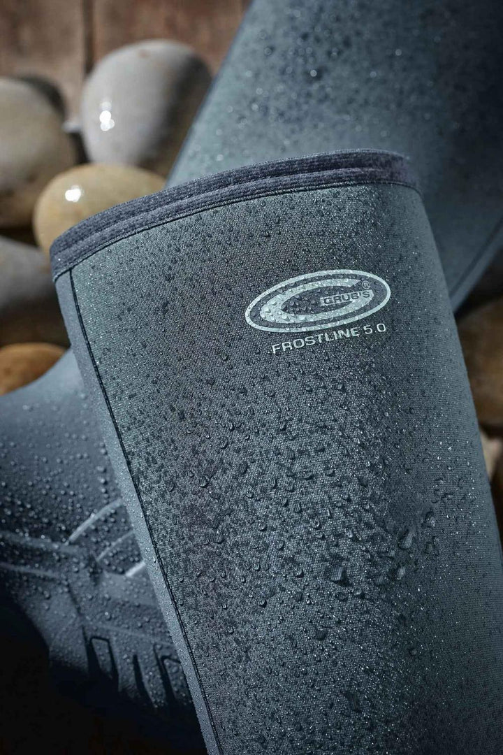 Close-up of the Grubs Frostline 5.0 logo on the grey neoprene shaft of the boot, with water droplets