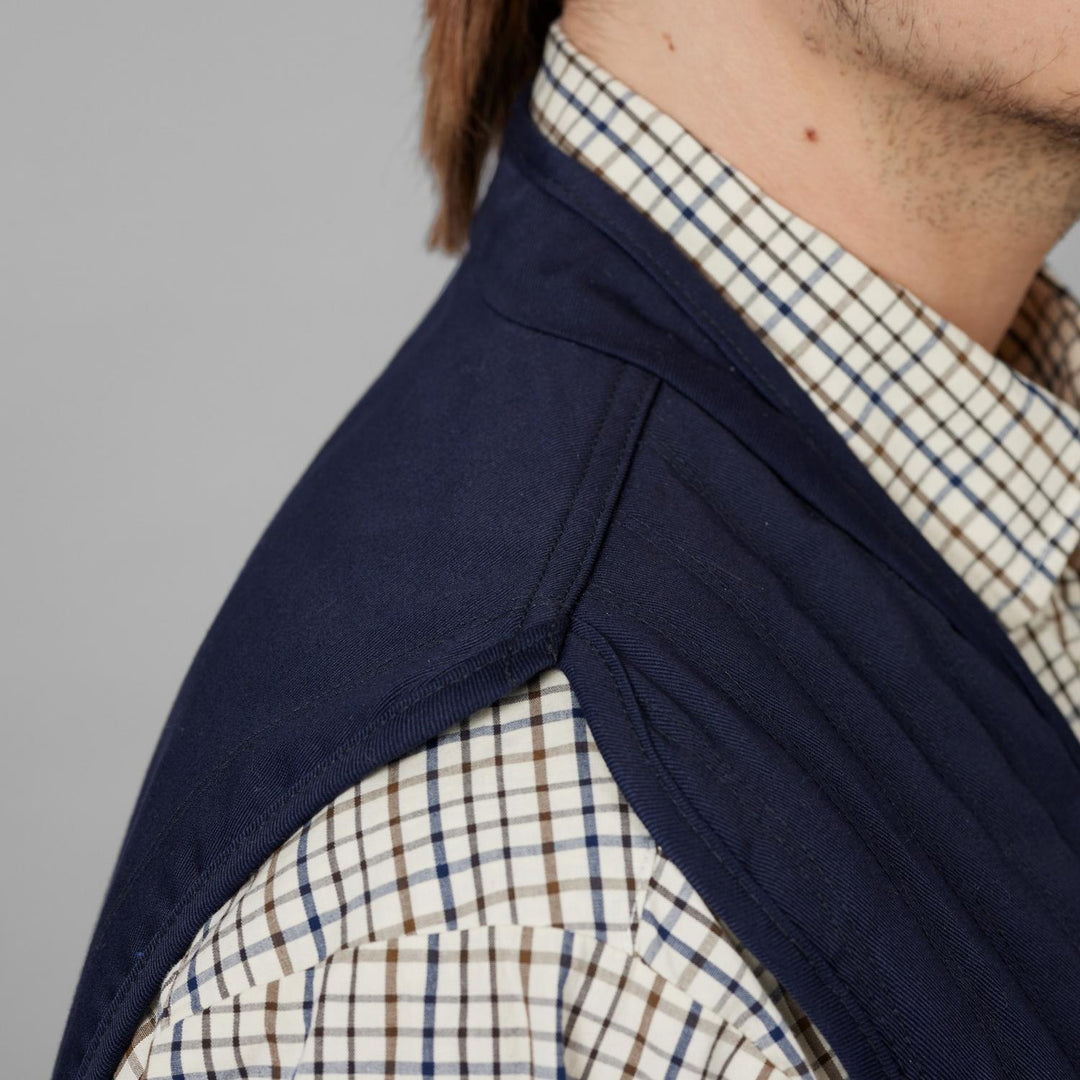 Detail of the Seeland Skeet II shoulder patch on a model, worn over a check shirt, showing the smooth navy mounting panel