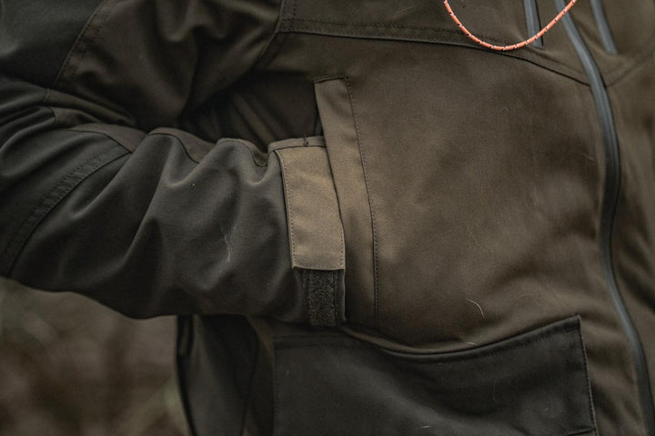 Detail of the Seeland Trax jacket hip, a hand slipped into the handwarmer pocket above the bellows pocket