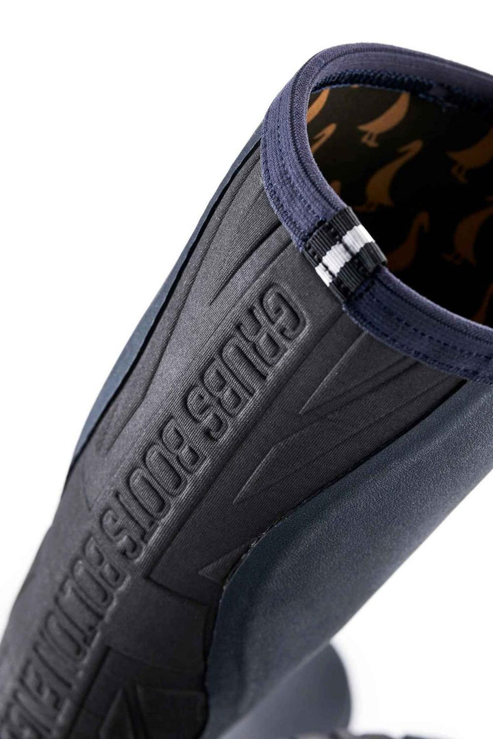 Rear detail of the navy Grubs Rainline 2.0 wellington boot with raised Grubs Boots lettering and duck-print lining at the top