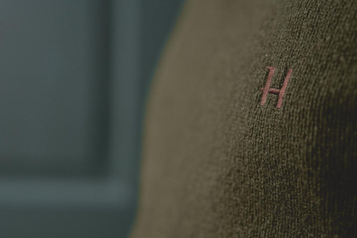 Harkila Vincent merino v-neck pullover in rosin green – view 9: close-up of the embroidered H emblem on the chest