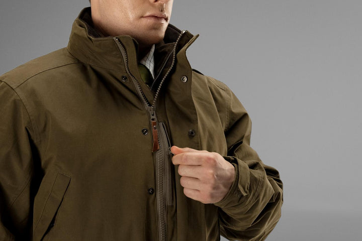Close-up of the Härkila Retrieve jacket collar, showing the fleece-lined stand collar, front zip and stud storm flap