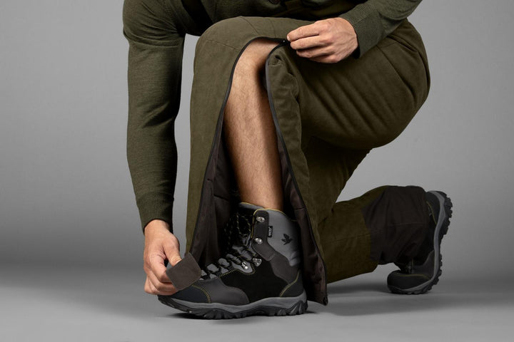 Person kneeling to adjust the inner ankle cuff of the Seeland Taiga trousers, showing the boot gaiter lining