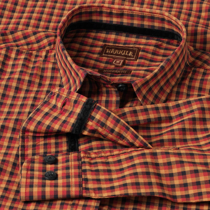 Close-up of the Harkila Selja shirt collar, showing the woven Harkila label and Modern Fit tab against the red and navy check.