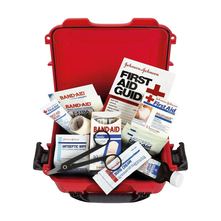 Nanuk 904 first aid case open from above, packed with plasters, antiseptic wipes, dressings, scissors and a Johnson & Johnson first aid guide