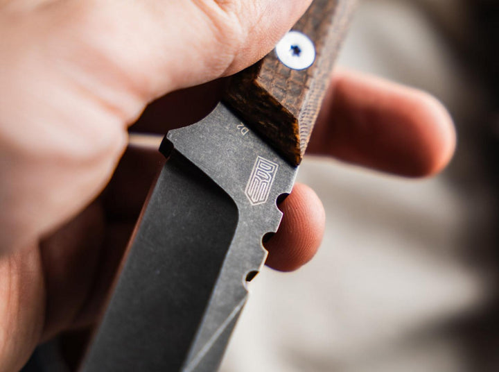Close-up of a hand holding the Böker Plus Thicker Clipper showing the stonewashed blade and brown handle