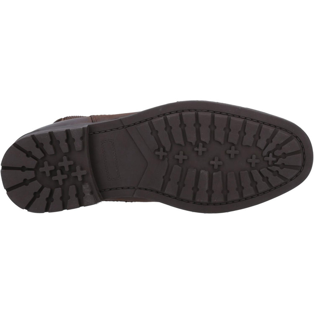 Underside of the Cotswold Gretton Chelsea boot, dark brown rubber outsole shown from below with a lugged heel and studded forefoot tread.