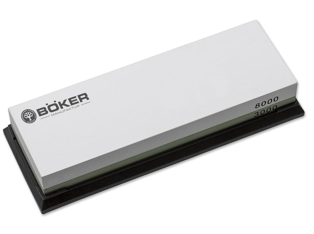 Böker Plus Water Stone 3000/8000 double-sided whetstone in white and grey on a black base, three-quarter view