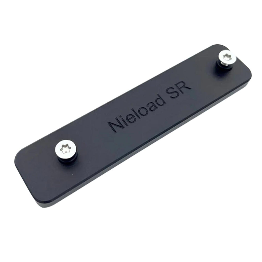 Nieload Swarovski SR rail adapter, flat black anodised plate engraved 'Nieload SR' with a Torx screw at each end, shown at an angle on white