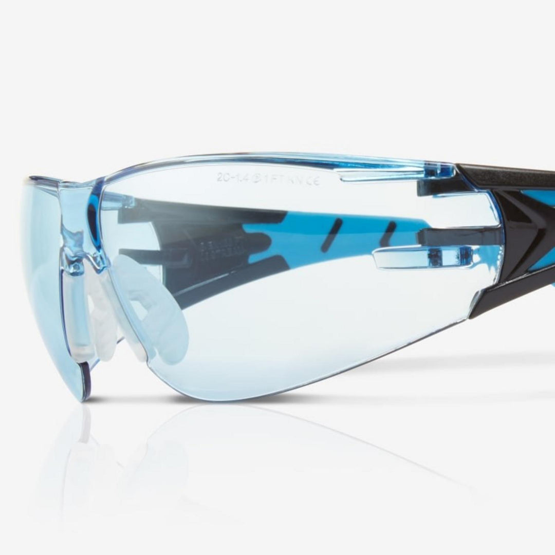 Riley Stream Blue safety glasses with blue tinted lens, close-up three-quarter view of the lens and hinge