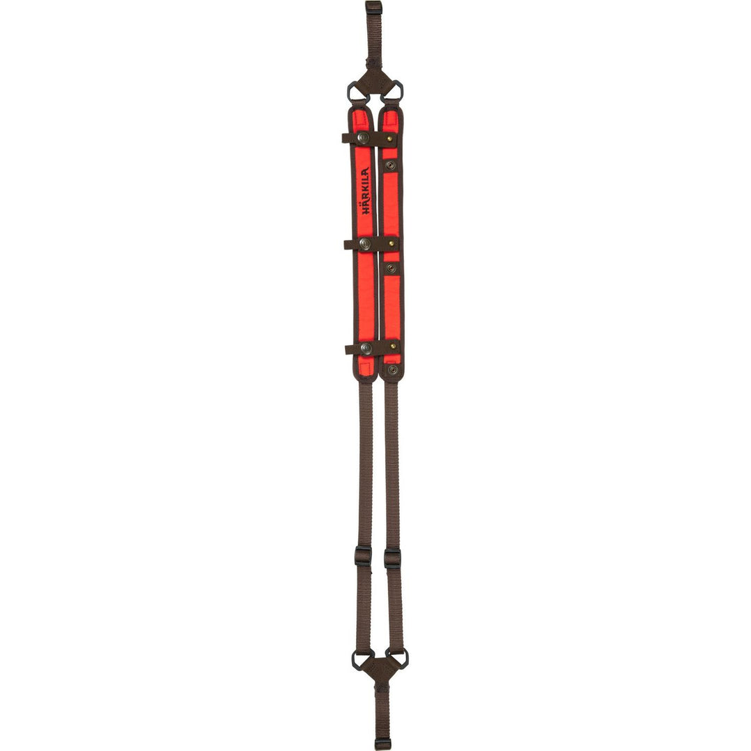 Härkila Wildboar Pro rifle sling laid flat on grey: blaze-orange padded shoulder sections with dark brown edging, Härkila branding and buckled attachment straps.