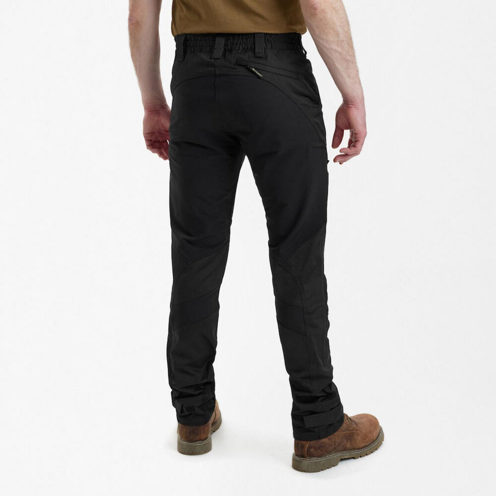 Deerhunter Rogaland Stretch Trousers Contrast Black on a model, back view with hands on hips, showing the rear yoke and tan boots