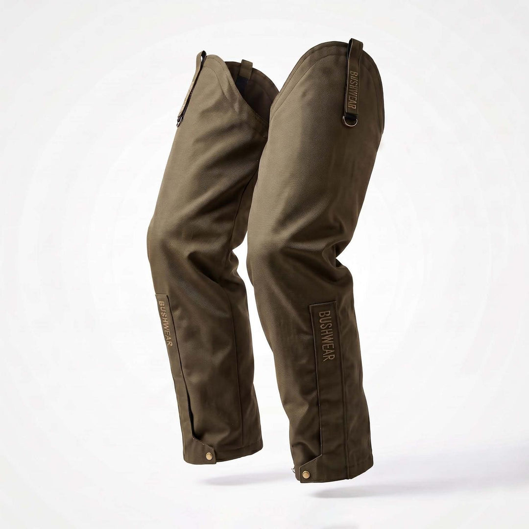 BushWear ThornGuard Pro Leggings product shot, the olive-green waterproof leg gaiters standing upright against white, three-quarter view showing both legs with top tab straps and side press studs