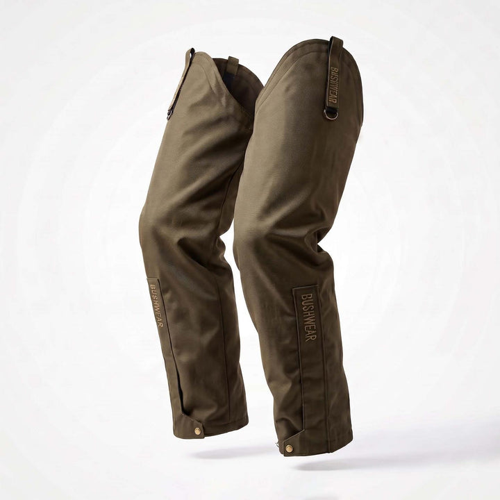 BushWear ThornGuard Pro Leggings product shot, the olive-green waterproof leg gaiters standing upright against white, three-quarter view showing both legs with top tab straps and side press studs