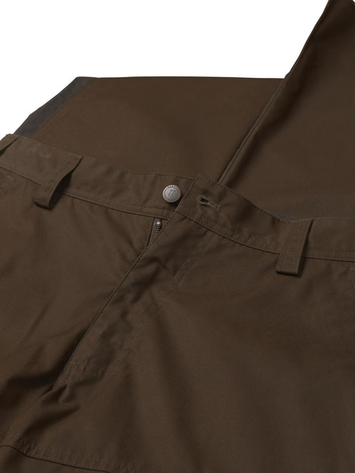 Detail of the Harkila Asmund trousers waistband: press-stud closure, zip fly, wide belt loops and the darker charcoal panel running down the lower leg.