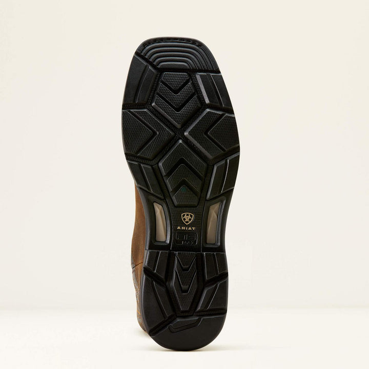 Ariat WorkHog XT outsole viewed from below at an angle, black lugged rubber tread with the Ariat shield badge