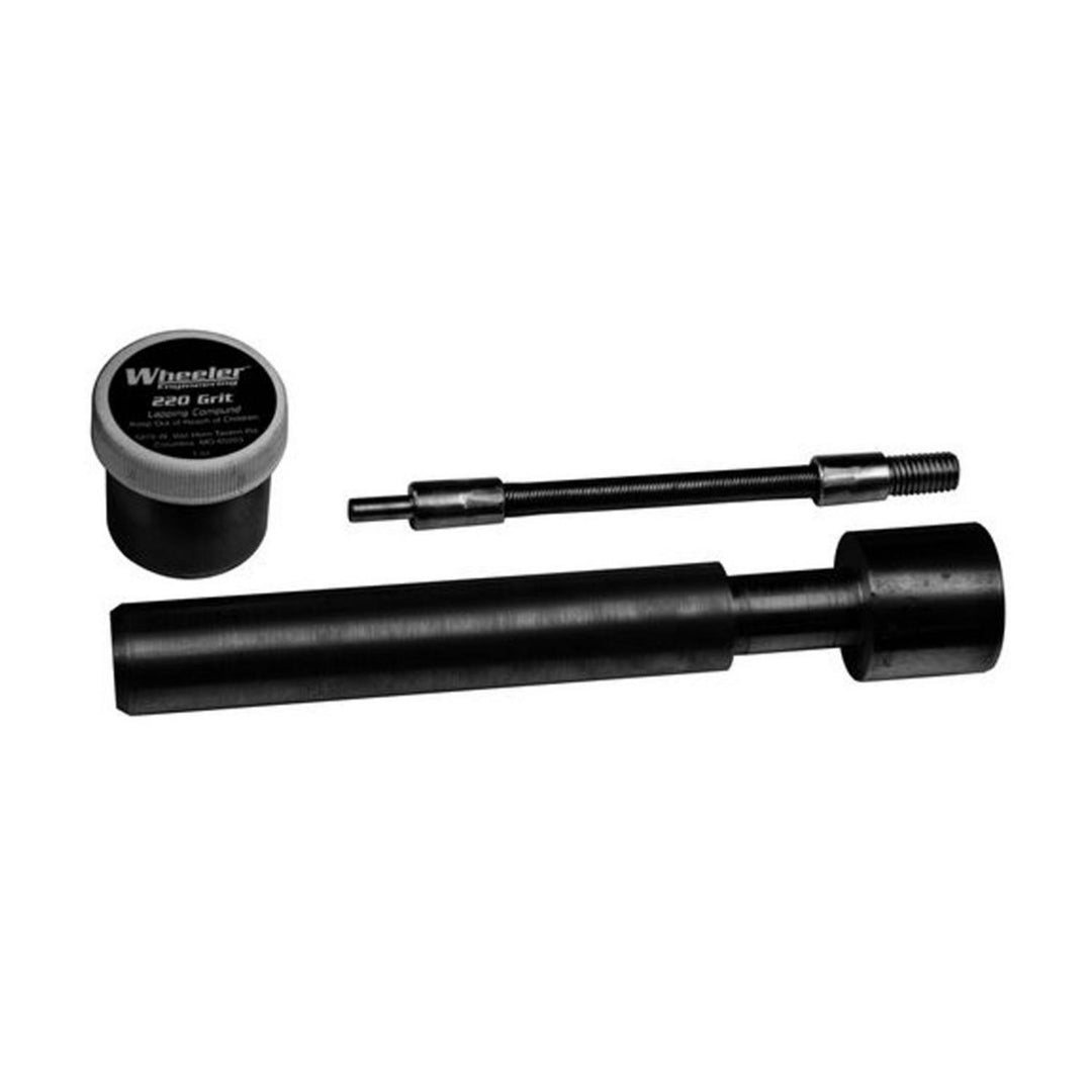 Wheeler AR-10 receiver lapping tool laid out on white: black lapping bar and threaded handle rod beside a tub of Wheeler 220 grit lapping compound