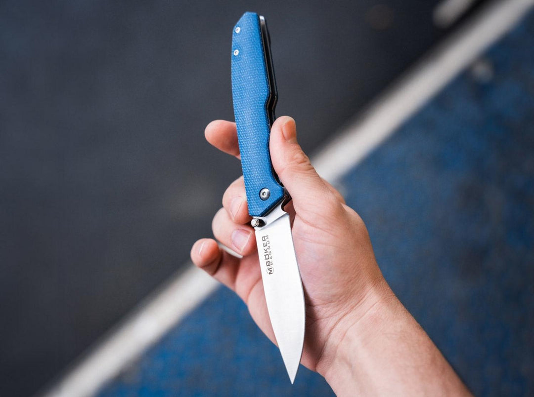 Hand holding the blue Böker Magnum Deep Blue Canvas folding knife with blade partly open, lifestyle shot