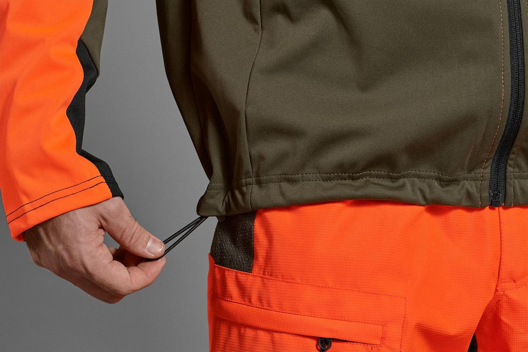 Seeland Force Advanced softshell jacket in blaze orange and dark olive – view 5: close-up of the elasticated hem and drawcord toggle on a grey background.