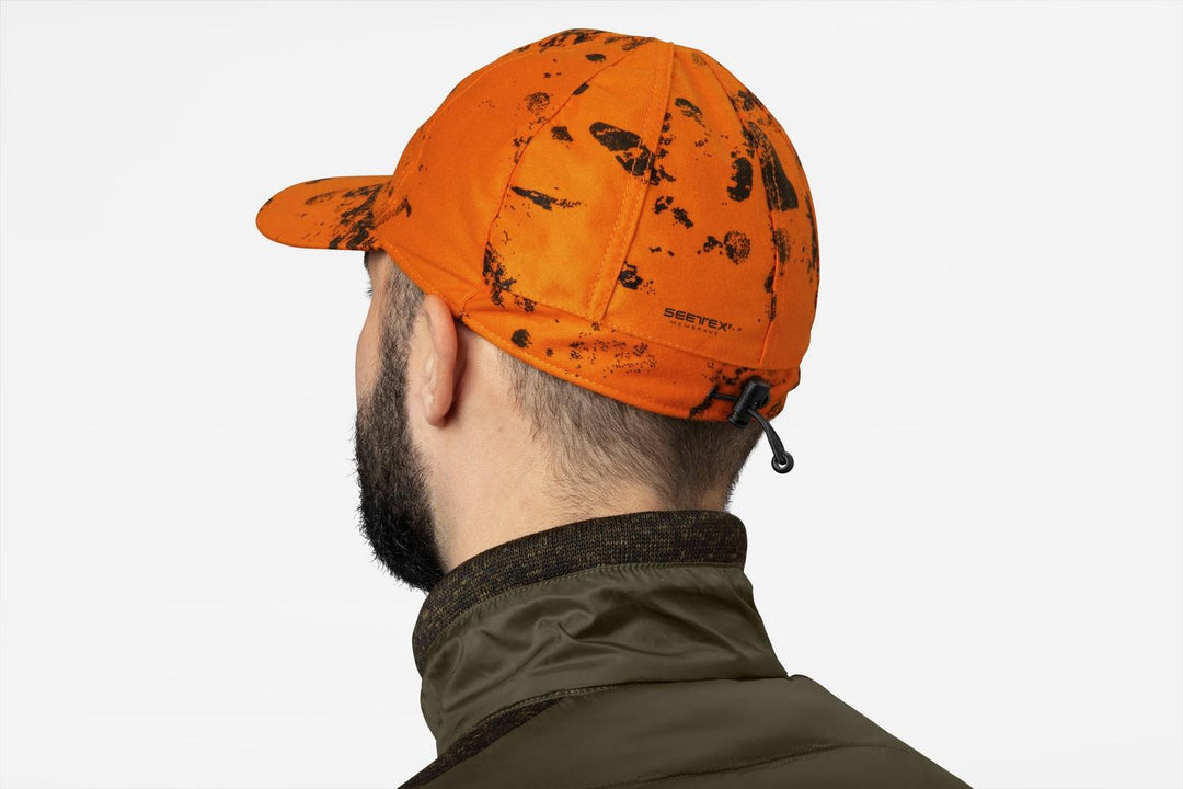 Seeland Avail Camo cap InVis orange blaze – view 3: worn from behind on a model over a dark green jacket, showing the rear adjuster.