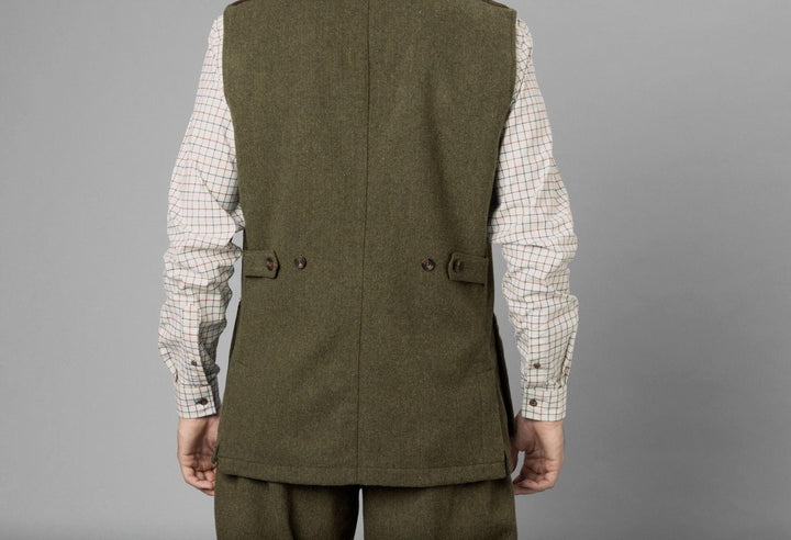 Studio rear three-quarter on grey, showing the waistcoat back, the buttoned half-belt and the shaped side seam.