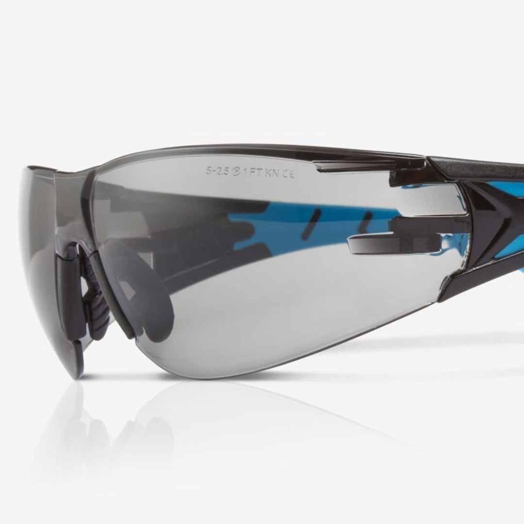 Riley Stream Blue safety glasses with grey lens, close-up three-quarter view of the lens and hinge