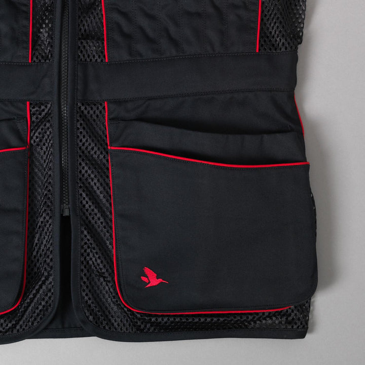 Close-up of the lower front pockets, red trim and the red Seeland flying-bird logo on the black twill