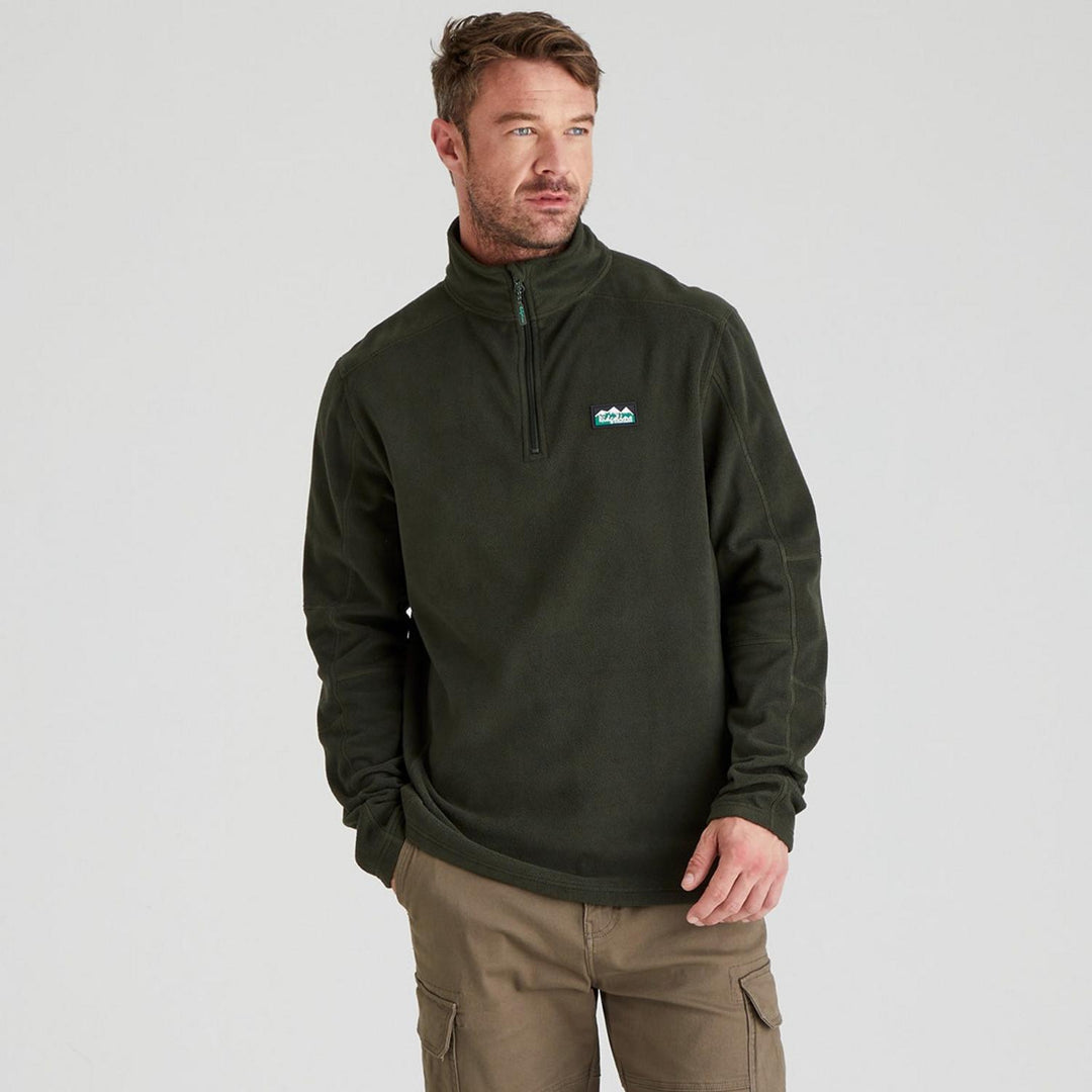 Male model wearing the Ridgeline Narvik fleece in dark forest green with tan cargo trousers, front view cropped at the hip, one hand in his pocket.