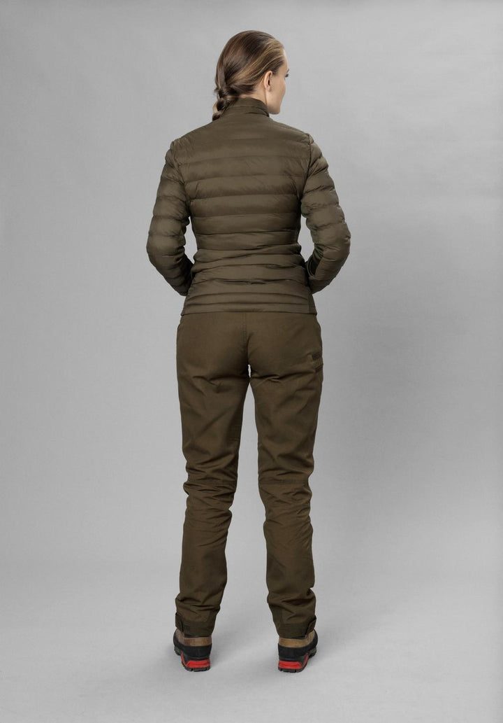 Full-length rear view of a model in the olive Seeland Therma Puffer Jacket with matching olive trousers and boots, grey studio backdrop.