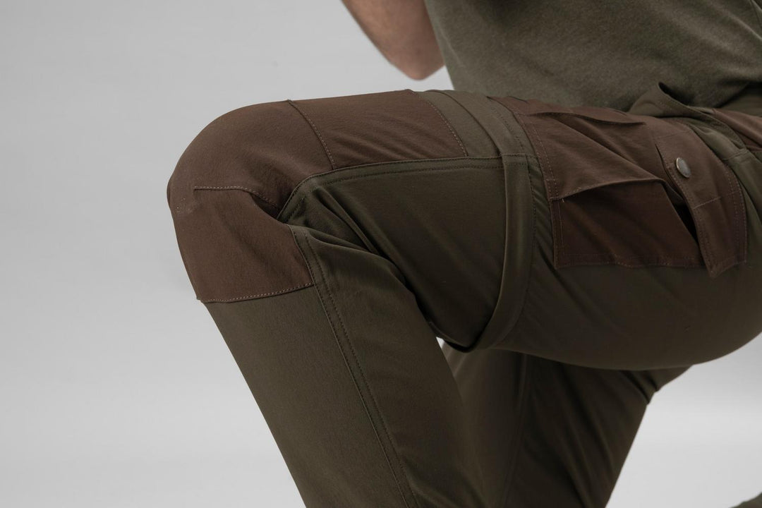 Model kneeling in the Seeland Birch trousers, rear three-quarter crop showing the articulated seat and stretch panels