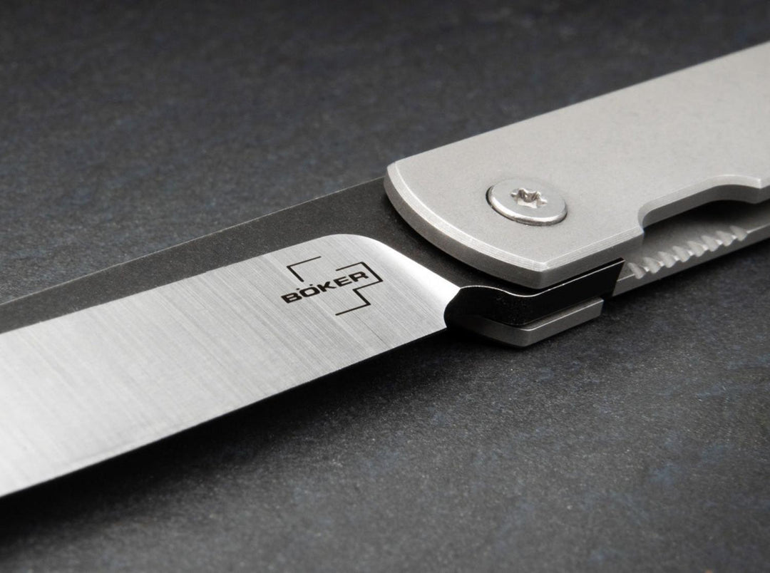 Close-up of the Böker logo on the satin and black blade of the Zenshin Framelock folding knife