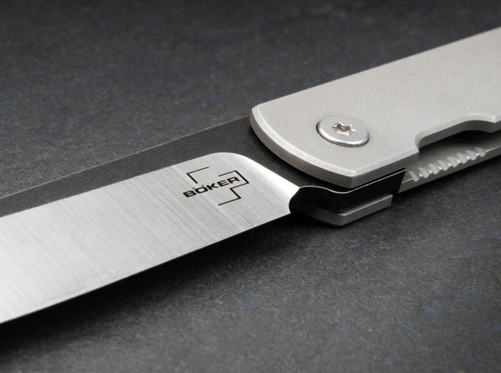 Close-up of the Böker logo on the satin and black blade of the Zenshin Framelock folding knife