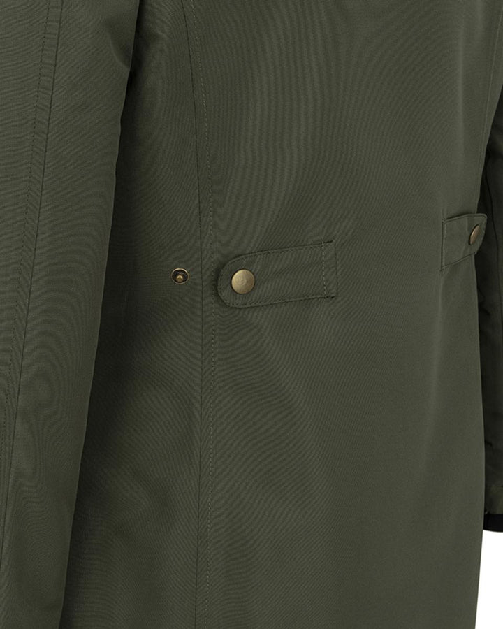 Close-up crop of the olive green Walker coat, showing the storm flap, antique brass press studs and the top of a flapped side pocket.