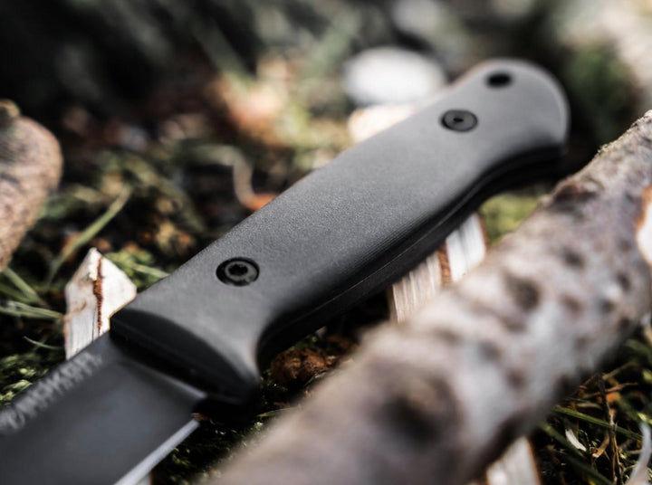 Böker DBK Bushfriend 2000 All-Black black handle close-up on a log in woodland, outdoor shot