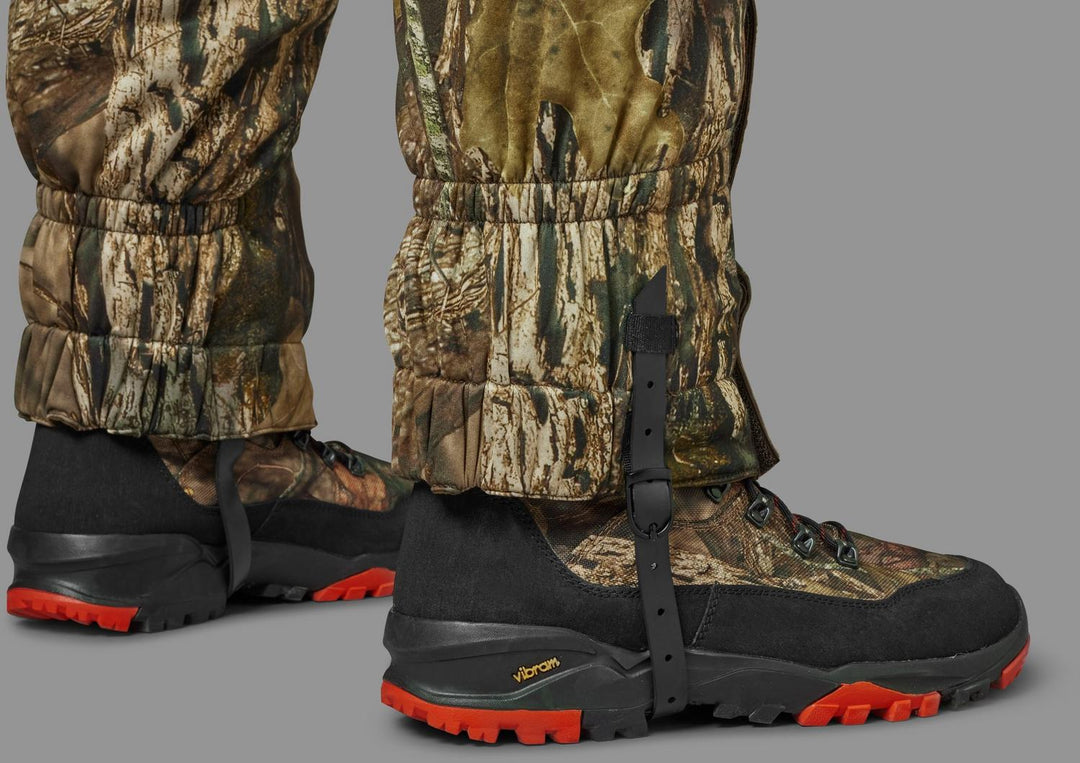 Both gaiters worn over camo hunting boots, seen from the front with the under-boot straps fitted.