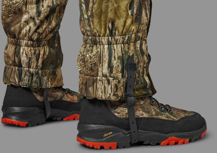 Both gaiters worn over camo hunting boots, seen from the front with the under-boot straps fitted.