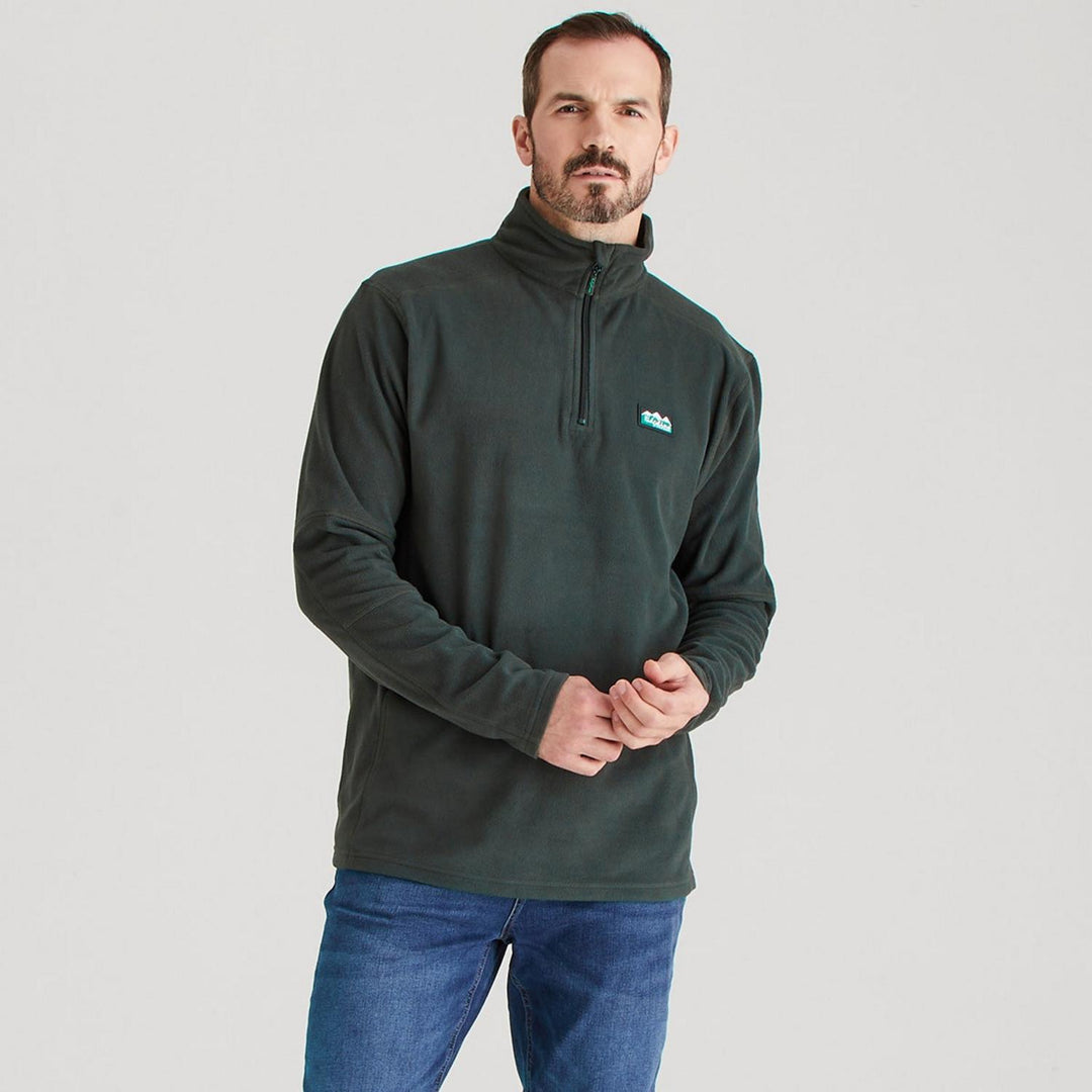 Male model wearing the Ridgeline Narvik fleece in dark green with blue jeans, front view with hands clasped in front, cropped at the hip.