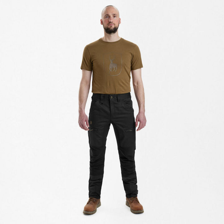 Full-length front view of a model wearing Deerhunter Rogaland Stretch Trousers Contrast Black with a tan Deerhunter branded t-shirt