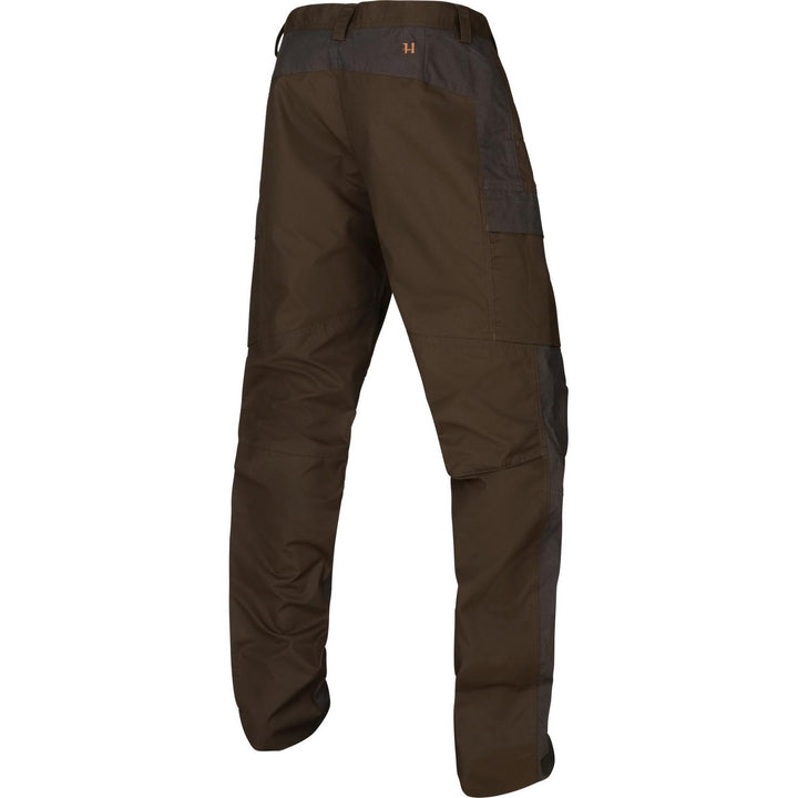 Three-quarter rear view of the Harkila Asmund trousers on an invisible mannequin, showing the charcoal seat reinforcement, articulated knees and gathered hems.