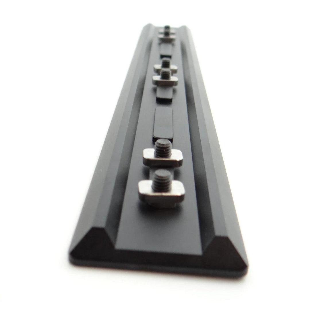 Nieload Tikka TAC A1 ARCA Swiss forend rail viewed end-on down its length, black anodised dovetail rail with two mounting nuts fitted