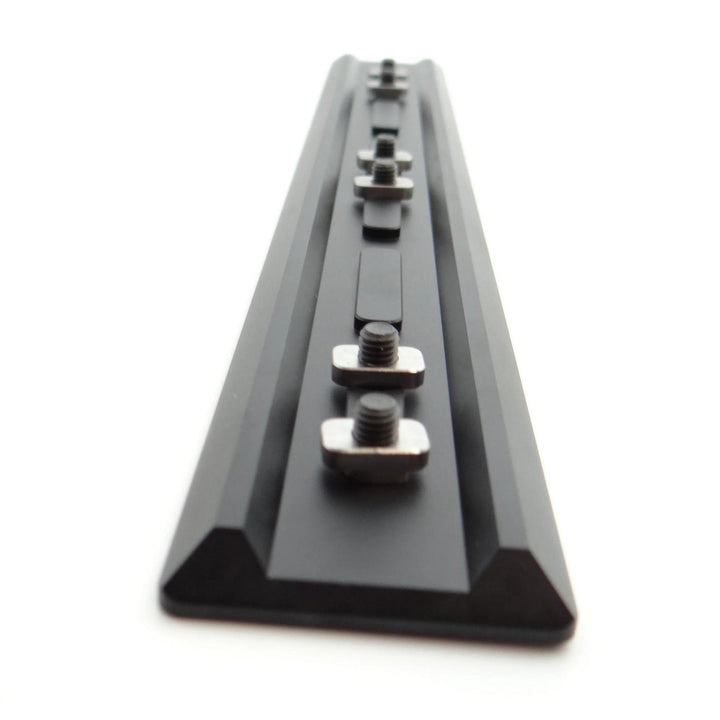 Nieload Tikka TAC A1 ARCA Swiss forend rail viewed end-on down its length, black anodised dovetail rail with two mounting nuts fitted