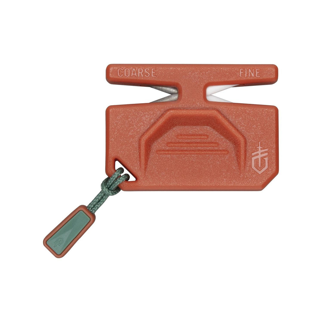 Gerber ComplEAT camp knife sharpener, burnt-orange plastic block marked Coarse and Fine over the two sharpening slots, with a green lanyard tab