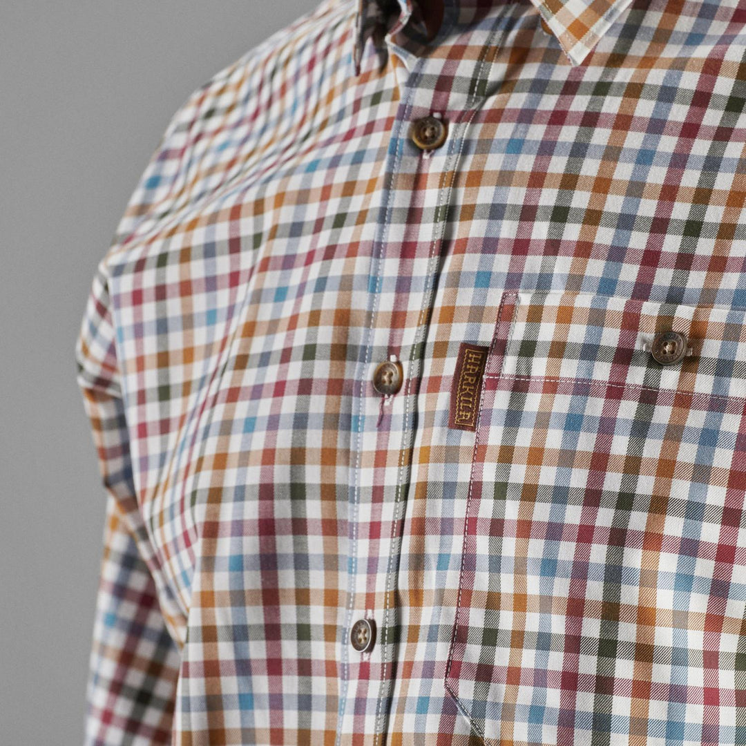 Close-up of the buttoned chest pocket and Härkila label on the multi-check Milford shirt