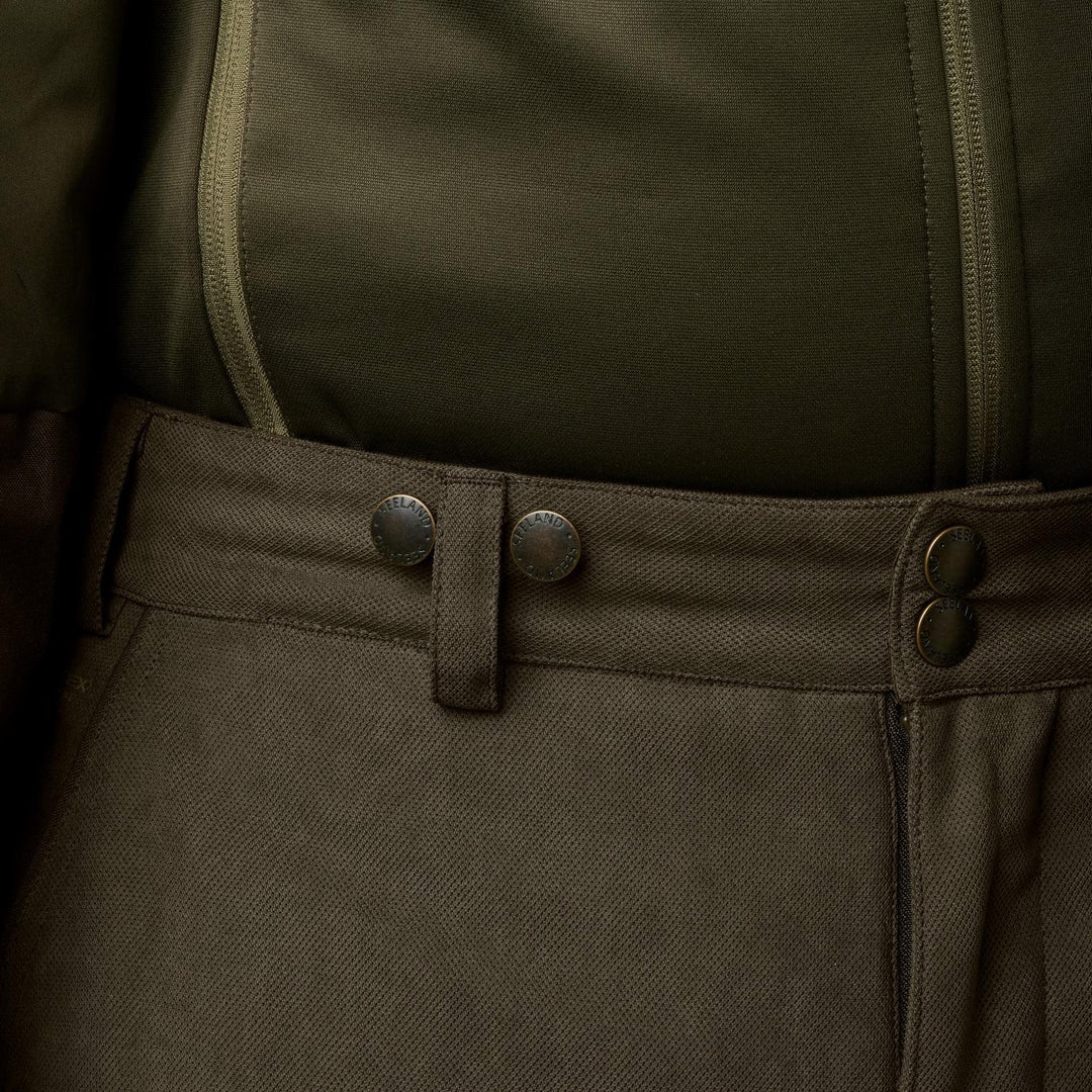 Close-up of the Seeland Helt II trousers' waistband with popper buttons, worn with braces