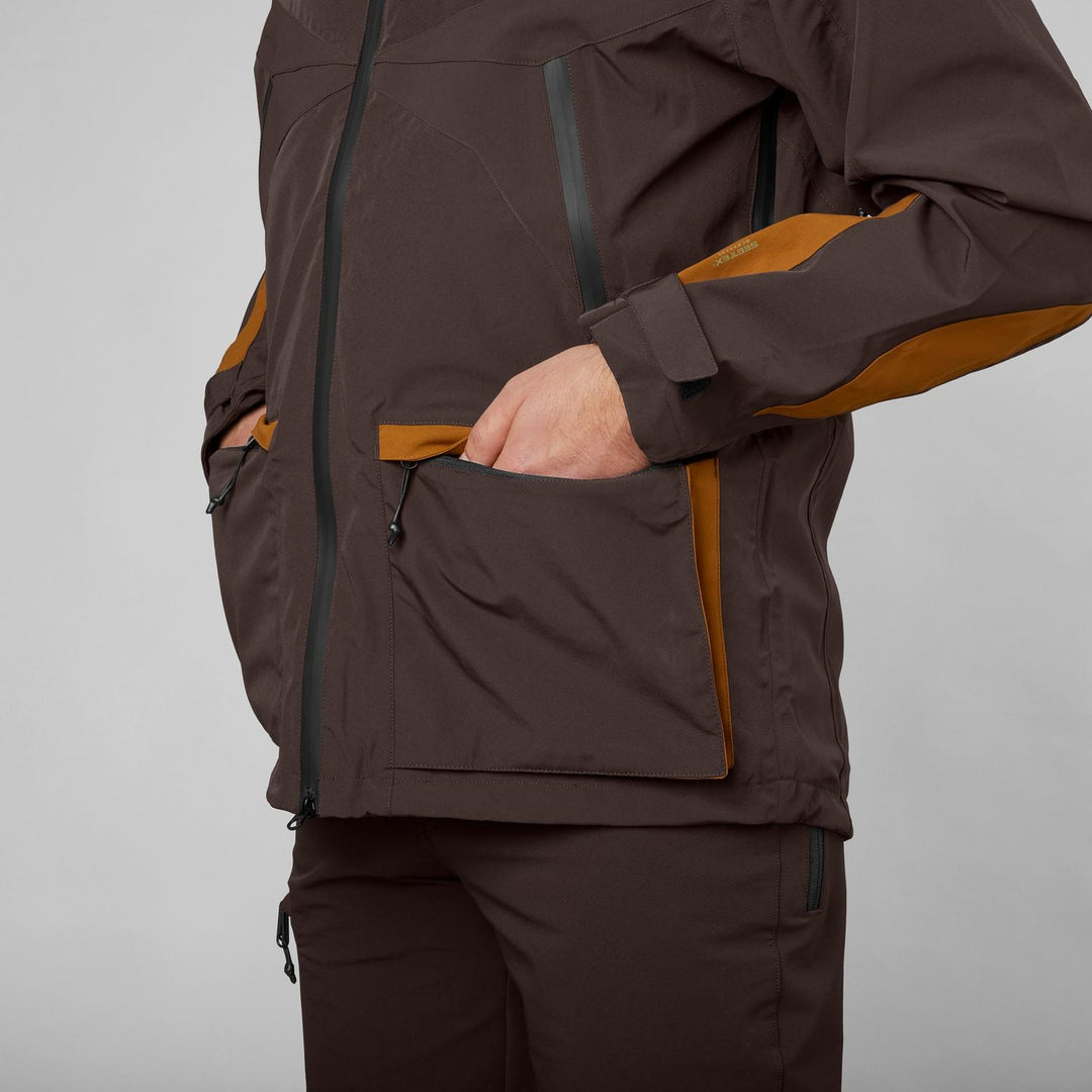 Close-up of a hand in the tan lower pocket of the Seeland Dog Active jacket, worn with matching trousers