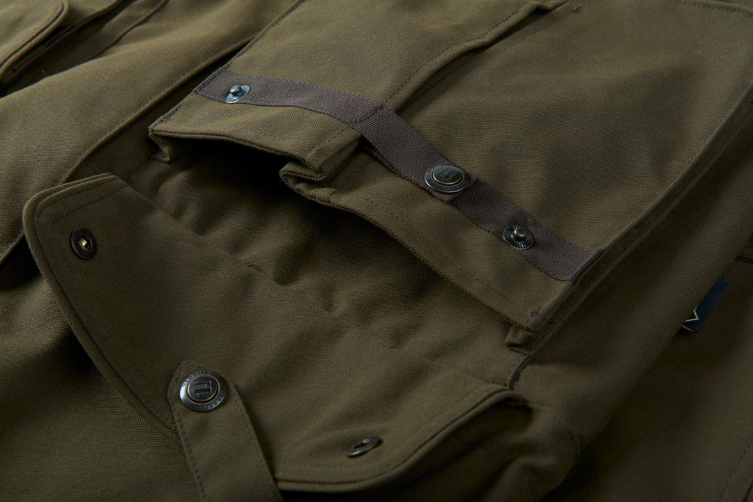 Close-up of the Härkila Pro Hunter Endure jacket shoulder, showing the press-studded shoulder strap and pocket flap