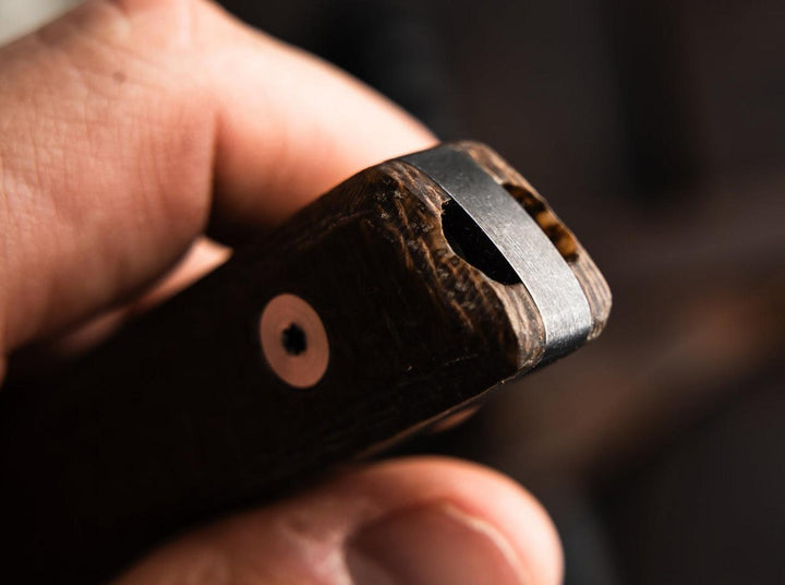 Close-up of the brown textured handle end and lanyard hole of the Böker Plus Thicker Clipper in hand