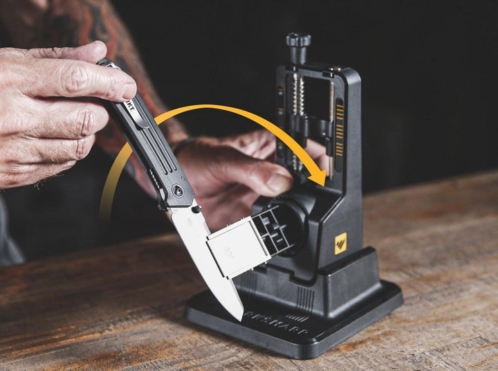 Lifestyle shot of a hand flipping a knife over in the Work Sharp Precision Adjust sharpener with an arrow showing the movement