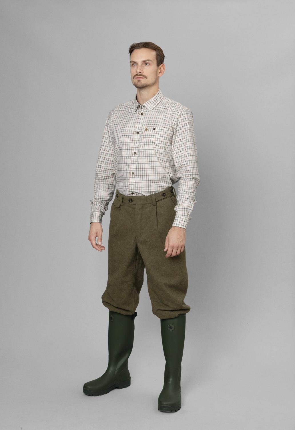 Full-length front view: model in Seeland Oxford check shirt, olive tweed breeks and green wellingtons